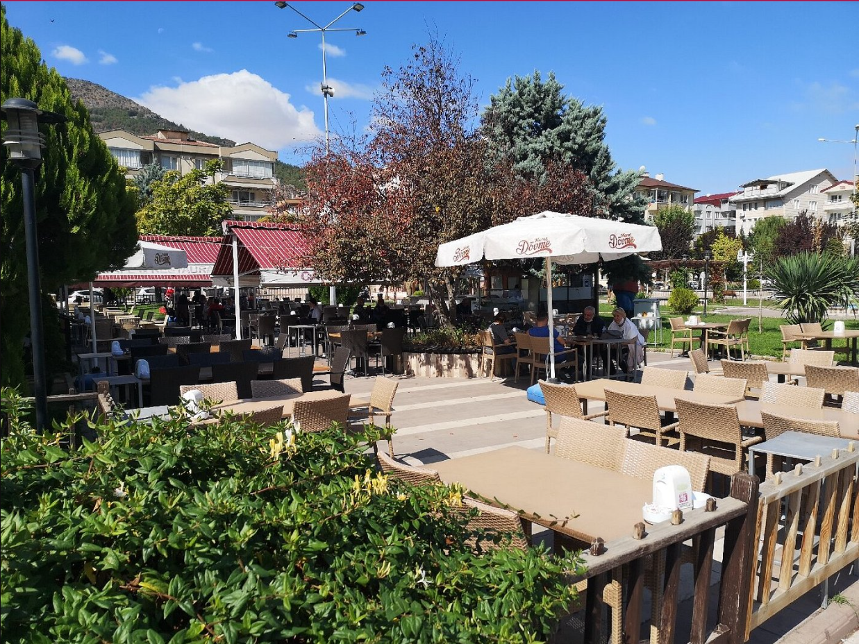 Hasbahçe restoranın bahçe alanı, masalar ve yeşil bitkiler